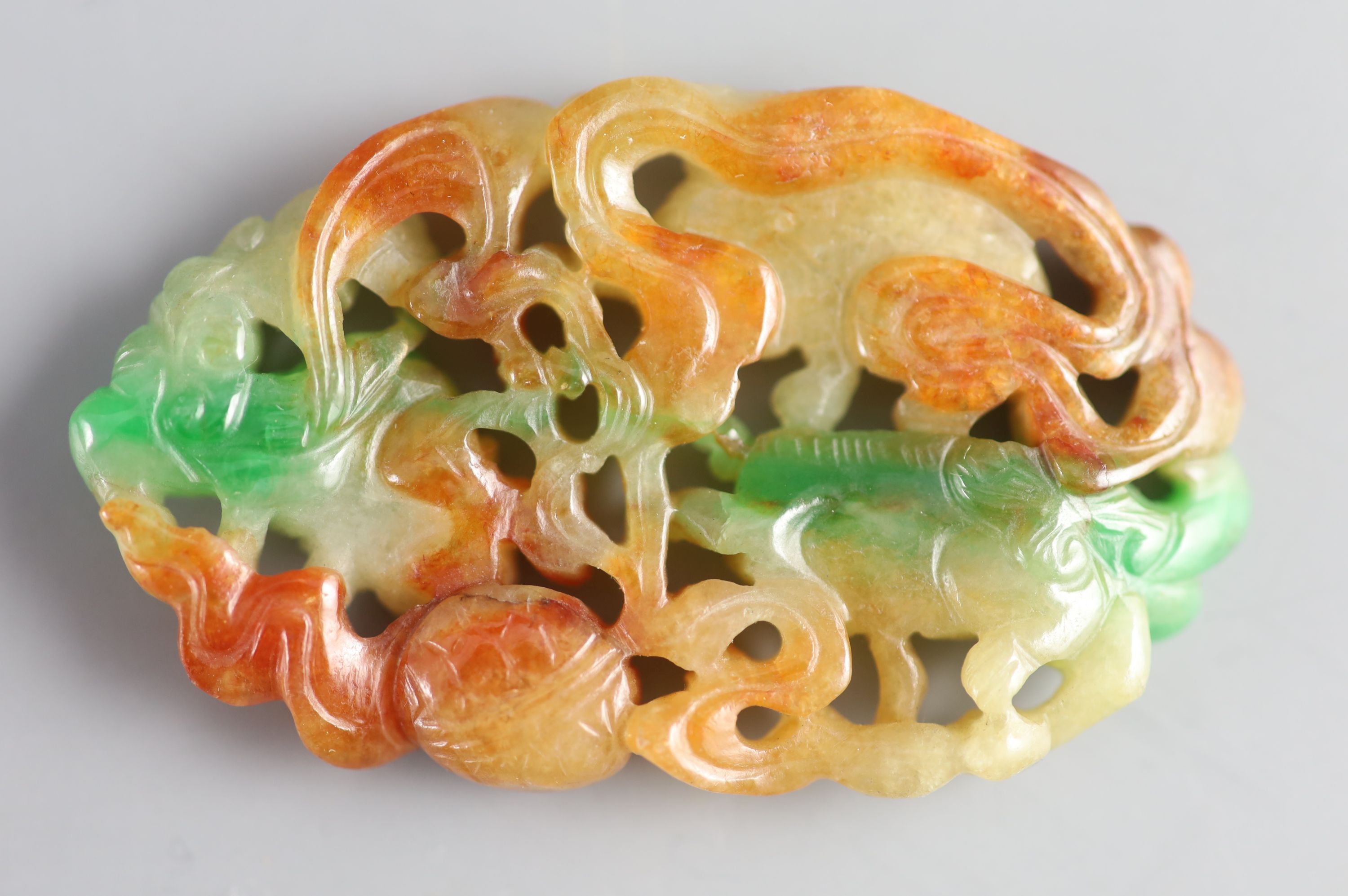 A Chinese three colour jadeite pendant plaque, 19th/20th century, 6.5cm